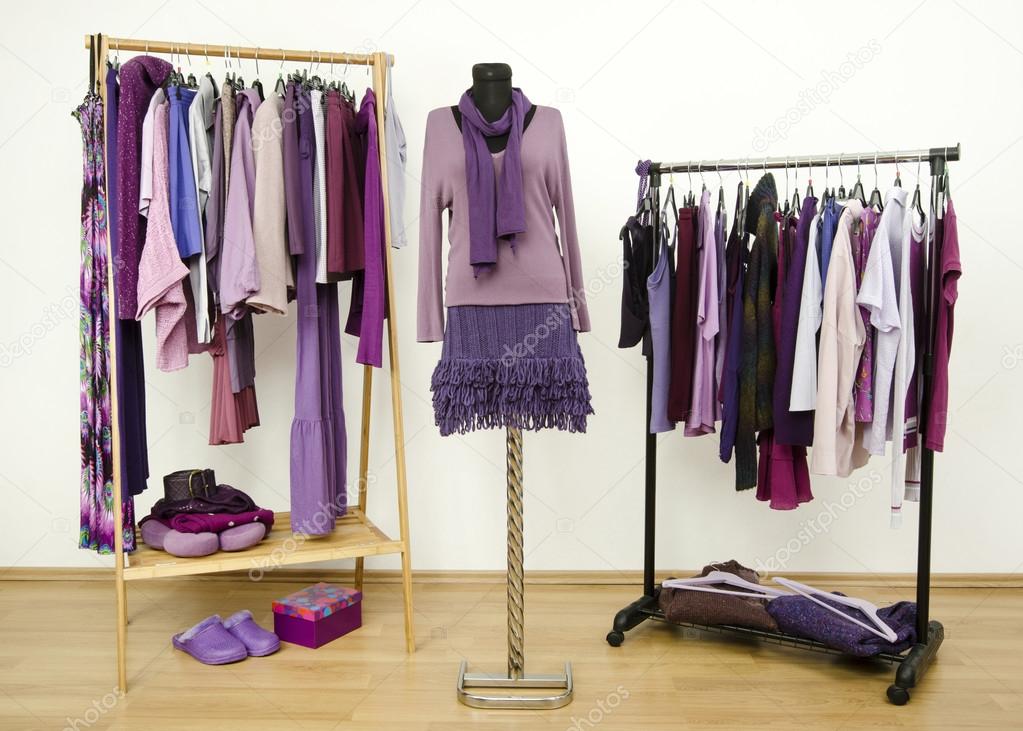 Wardrobe with purple clothes arranged on hangers and an outfit on a mannequin.