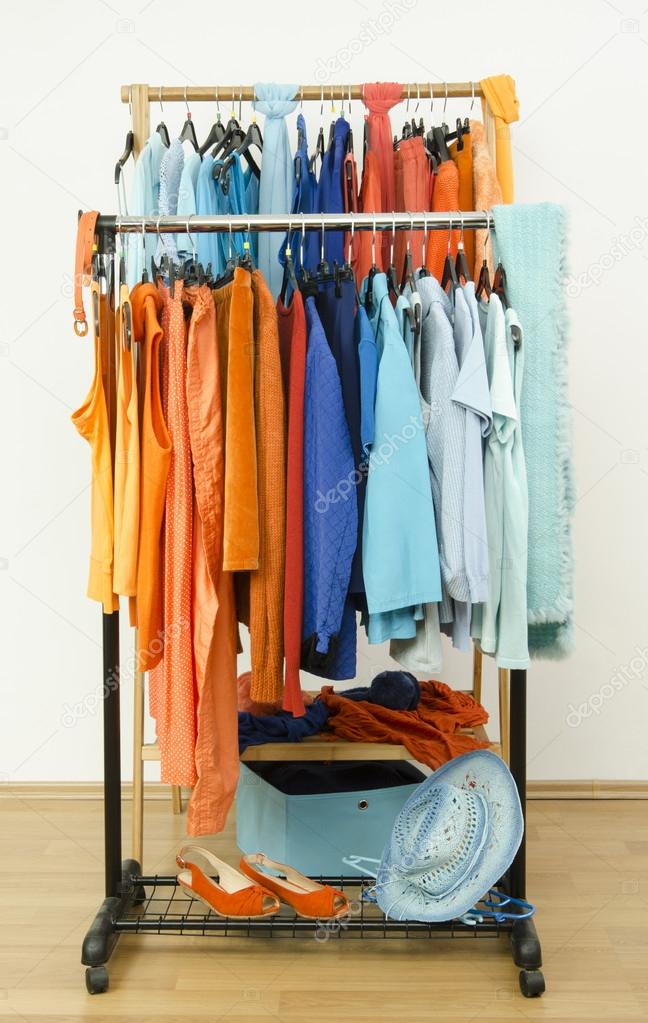 Wardrobe With Complementary Colors Orange And Blue Clothes Arranged On  Hangers. Dressing Closet With Clothes, Shoes And Accessories And A Dress On  A Mannequin. Stock Photo, Picture and Royalty Free Image. Image