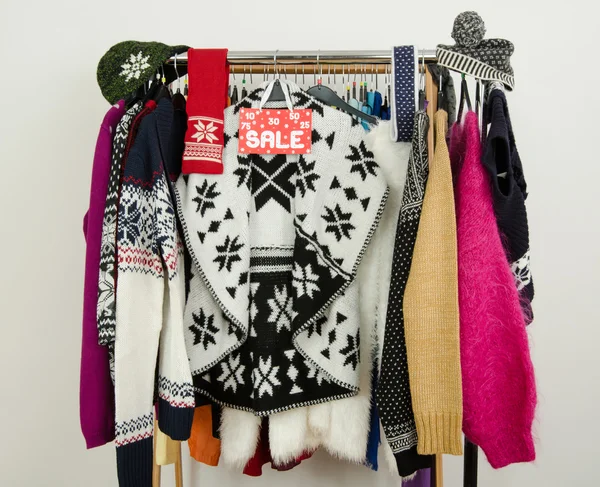 Cute winter sweaters displayed on hangers with a big sale sign. — Stock Photo, Image