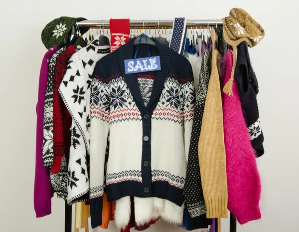 Cute winter sweaters displayed on hangers with a big sale sign. — Stock Photo, Image