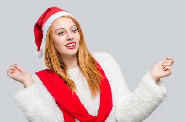 Schöne junge Frau mit Weihnachtsmütze lächelnd zur Seite schauend. — Stockfoto