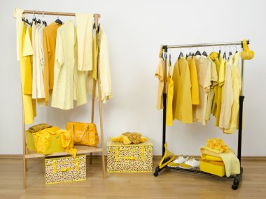 Sarı elbise askıları düzenlenmiş Soyunma Dolabı. 