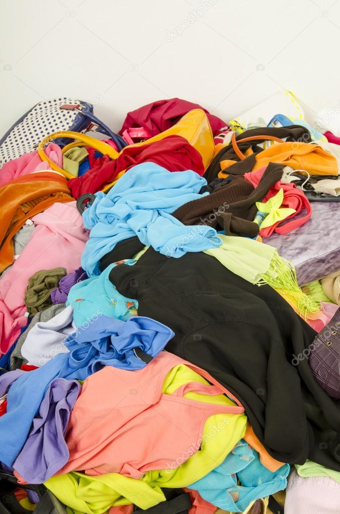 Close up on a big pile of clothes and accessories thrown on the ground.