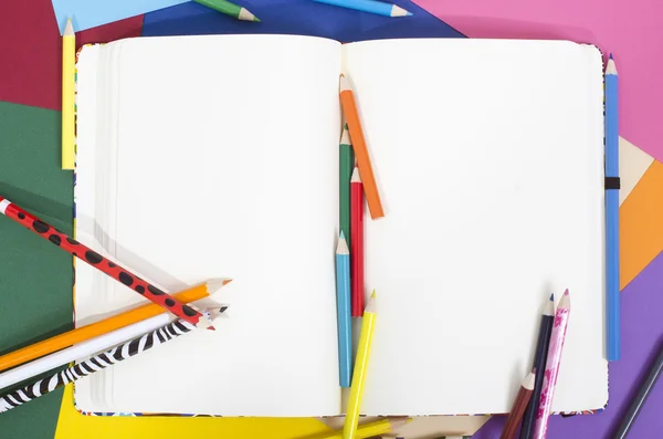 Caderno em branco com lápis de cor . — Fotografia de Stock