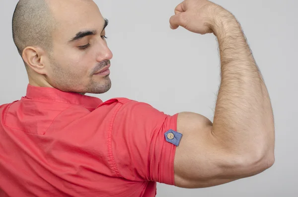 Fit mens poseren met zijn arm omhoog tonen zijn biceps. — Stockfoto