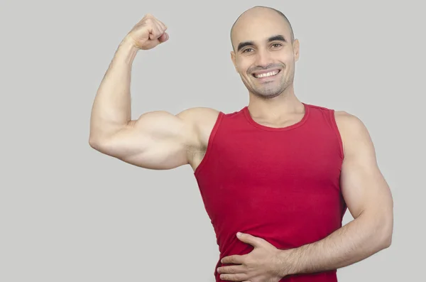 Construtor de corpo feliz mostrando seu bíceps . — Fotografia de Stock
