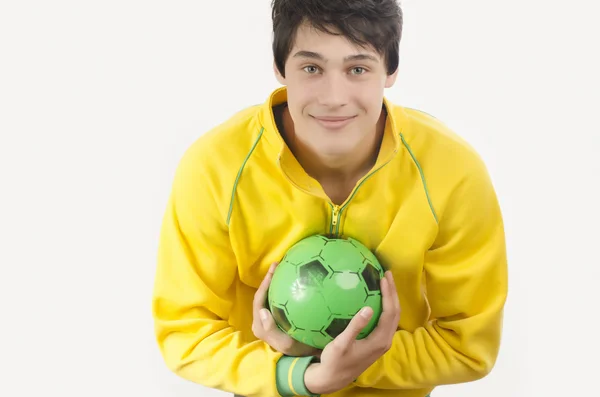 Mladý muž chytání fotbalový míč. — Stock fotografie