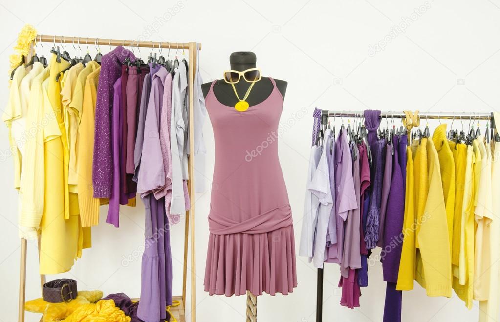 Dressing closet with complementary colors violet and yellow clothes.