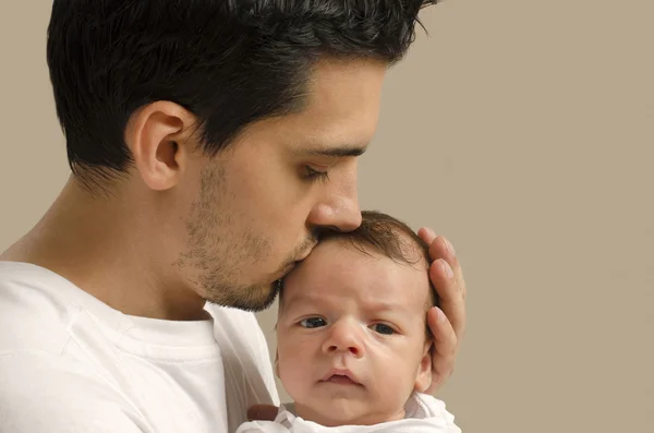 Pai amoroso beijando seu bebê recém-nascido . — Fotografia de Stock