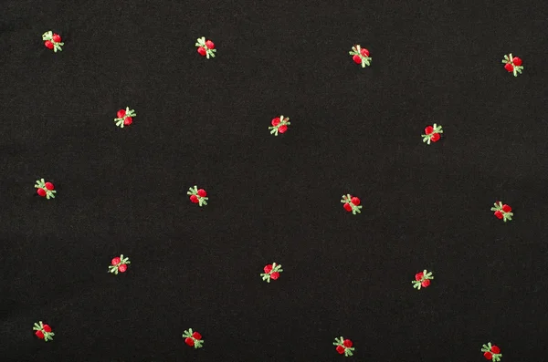 Small red floral pattern on black fabric. — Stock Photo, Image