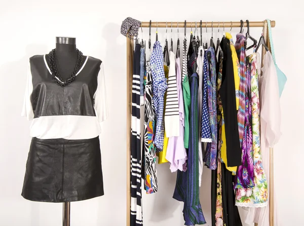 Dressing closet with colorful clothes arranged on hangers and an — Stock Photo, Image