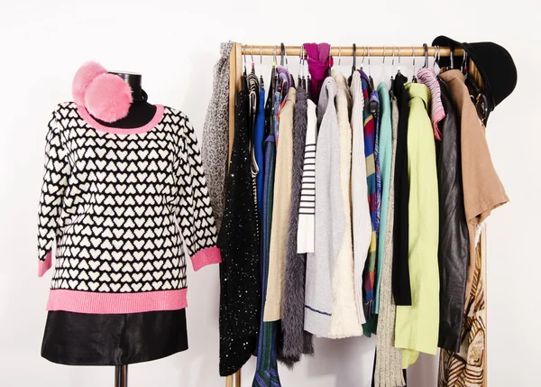 Wardrobe with winter clothes arranged on hangers and an outfit o — Stock Photo, Image