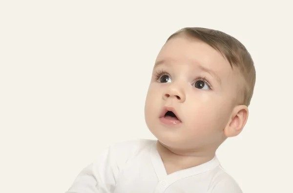 Söt baby pojke tittar upp förvånad. — Stockfoto