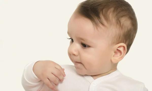 Söt baby pojke tittar på sidan. — Stockfoto