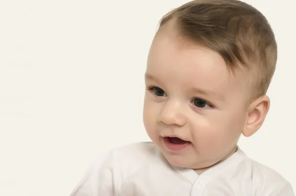 Söt baby pojke tittar ner leende. — Stockfoto