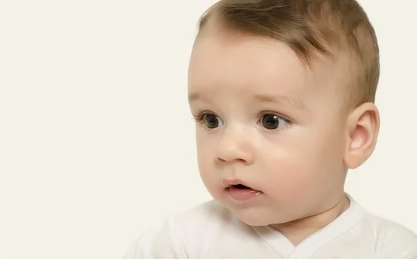 Aranyos baba fiú keresi, hogy a meglepett oldalon. — Stock Fotó