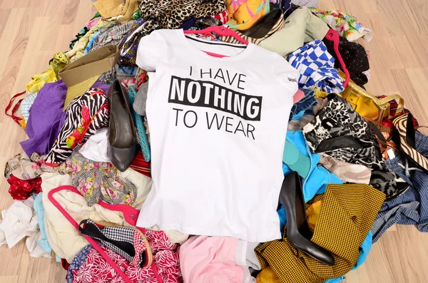 Big pile of clothes thrown on the ground with a t-shirt saying n — Stock Photo, Image