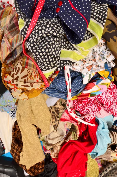 Close up on a big pile of clothes and accessories thrown on the — Stock Photo, Image