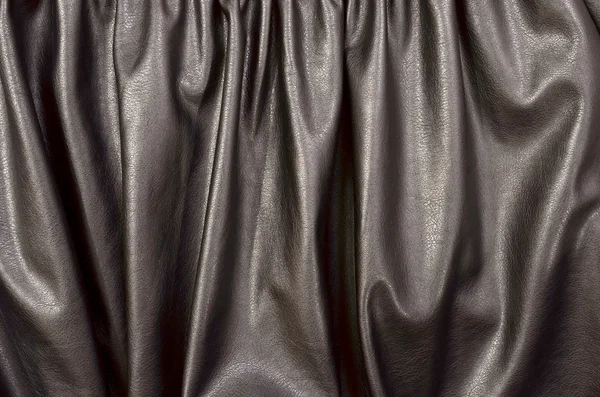 Close up on crumpled black leather material textured fabric.