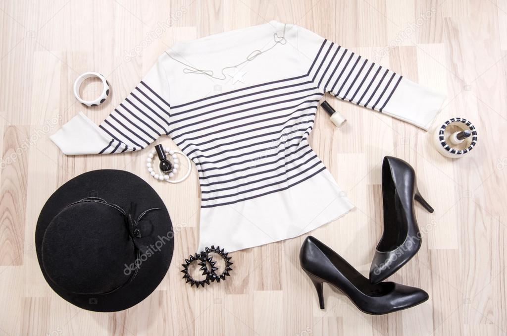 Striped blouse with accessories arranged on the floor.