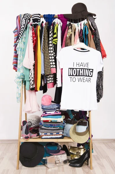 Muitas roupas no rack com uma camiseta dizendo nada para usar . — Fotografia de Stock