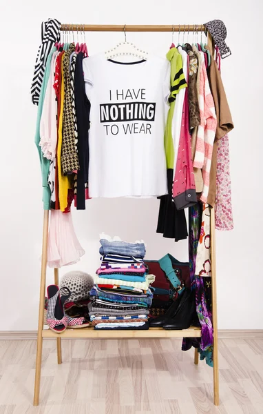Muitas roupas no rack com uma camiseta dizendo nada para usar . — Fotografia de Stock
