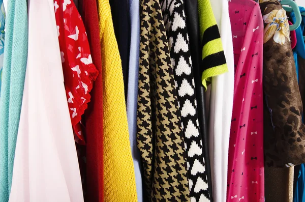 De cerca en ropa colorida en perchas en una tienda . — Foto de Stock