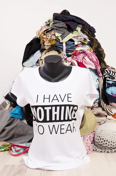 Big pile of clothes thrown on the ground with a t-shirt saying nothing to wear. — Stock Photo, Image