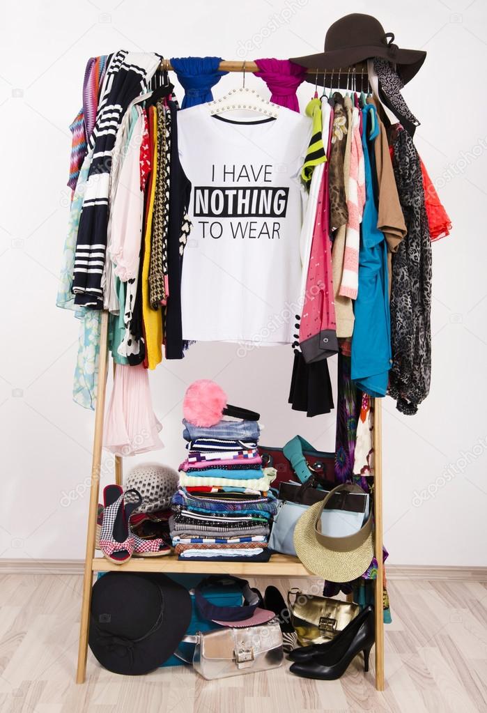 Many clothes on the rack with a t-shirt saying nothing to wear. 