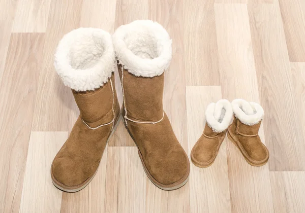 Par de botas de mulher de inverno e par semelhante de botas de criança . — Fotografia de Stock