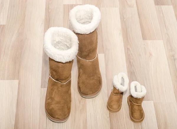 Par de botas de mujer de invierno y un par de botas de niño similares . — Foto de Stock