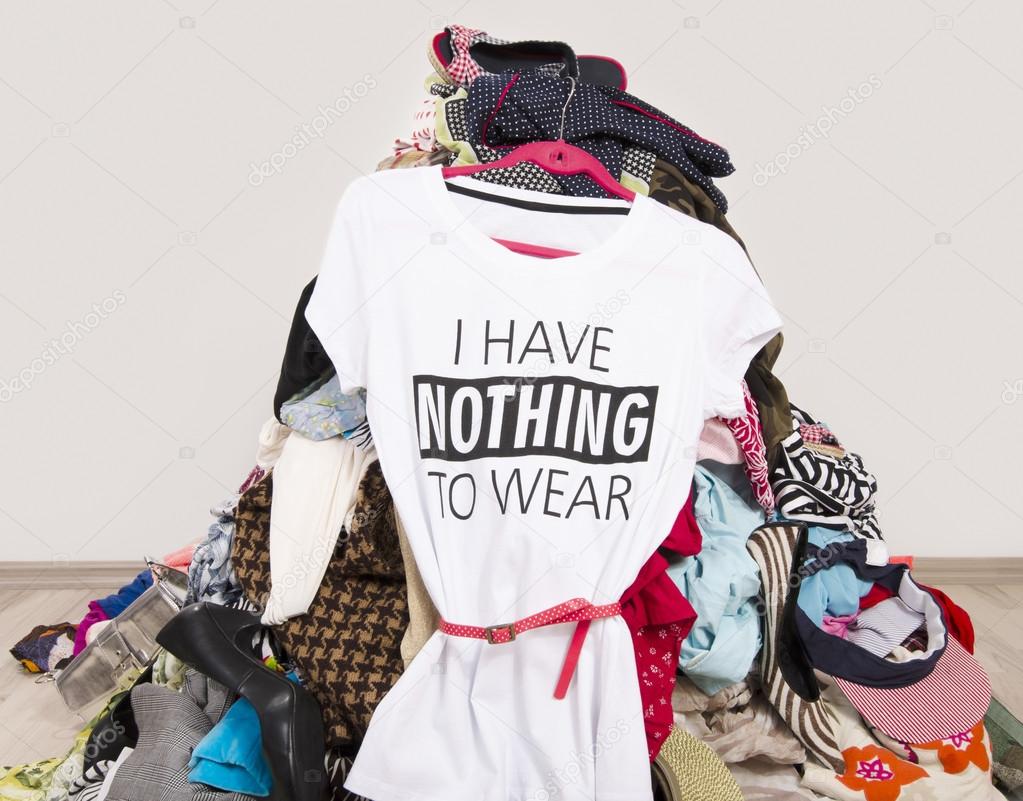 Big pile of clothes thrown on the ground with a t-shirt saying nothing to wear.
