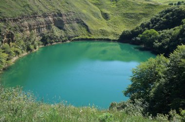 Shadhurei Dağı 'nın karst dağı manzarası yazın Kuzey Kafkasya dağlarındaki Kabardino-Balkaria' nın Zolsk bölgesinde yeşil bitki örtüsüyle çevrilidir.                               
