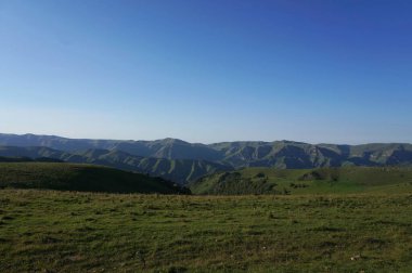 Kafkas akşam dağlarının panoraması mavi gökyüzü ve Shadzhatmaz yüksek platosundan gelen bulutlar Kuzey Kafkasya 'da                               