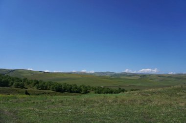 Kuzey Kafkasya dağlarındaki Dzhily-su Platosu 'nda yaz mevsiminde dağları ve mavi gökyüzünü görmek                              