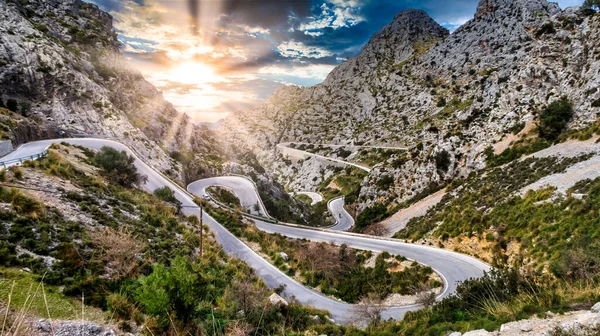 Günbatımlı Serpentine Yolu ve Mayorka, Mallorca Adası 'nda bir bisikletçi.