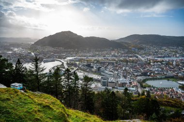 Bergen 'in yağmurlu bir günde modern ve geleneksel mimarinin bir karışımıyla yuvarlanan tepeler ve nehir arasında yuva yapmış panoramik bir görüntüsü, Norveç