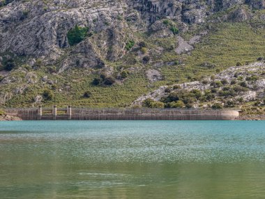 Gorg Blau kurak göl barajı, Mallorca, sakin bir su kütlesi boyunca uzanır, engebeli, yeşil bir yamaçta, Mayorka 'da.