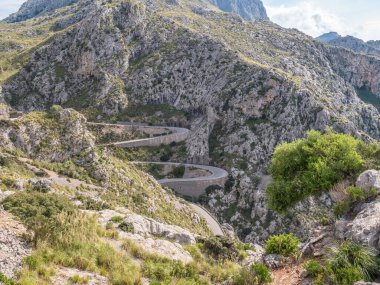 Sa Calobra, Mallorca 'ya giden Serpentine yolu, engebeli dağlarda kıvrılan yol yılanları, yeşil bitki örtüsüyle çevrili, Majorca