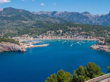 Port de Soller, Mallorca, yemyeşil tepeler ve limana yanaşmış sayısız tekneyle birlikte sakin mavi bir körfez arasında yuva yapmış, geniş açılı bir kasaba, Majorca.