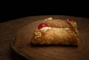 Tahta kesim ve çuval bezi üzerine iki canoli yakın plan..