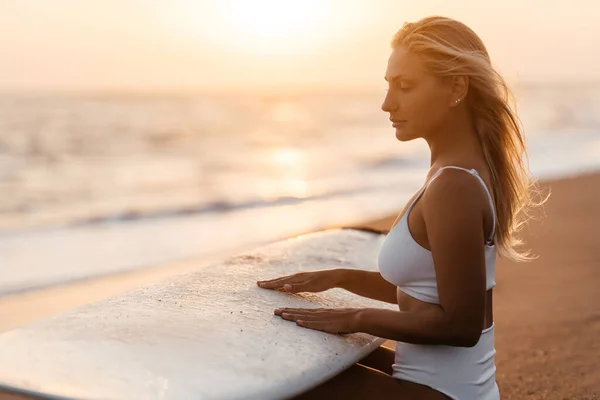 Hermosa mujer surfista en la playa al atardecer —  Fotos de Stock