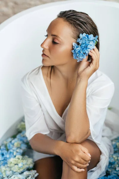 Mulher relaxante no banho com hortênsia azul tropical. — Fotografia de Stock