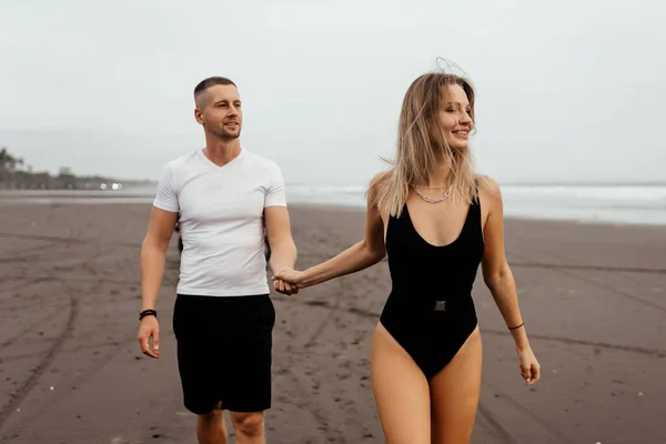 Al aire libre de sonriente joven pareja caminando en la playa. —  Fotos de Stock
