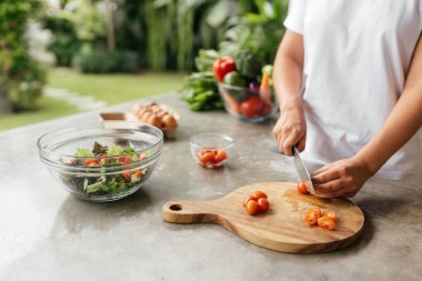 İnsan elleri mutfakta sebze salatası pişiriyor.