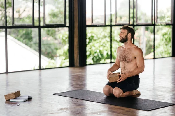 Yoga men workout in studio in front of a window