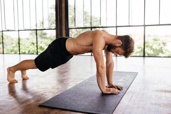 Entrenamiento para hombres de yoga en estudio frente a una ventana — Foto de Stock