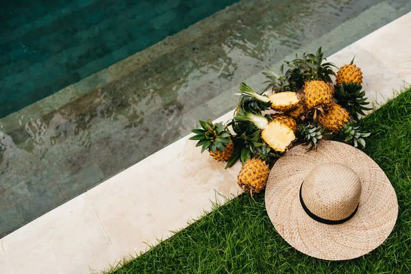 Abacaxis maduros deliciosos com chapéu à beira da piscina. Bali Indonésia. — Fotografia de Stock