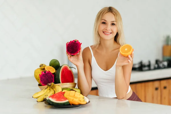 Frau lächelt mit tropischen Früchten — Stockfoto