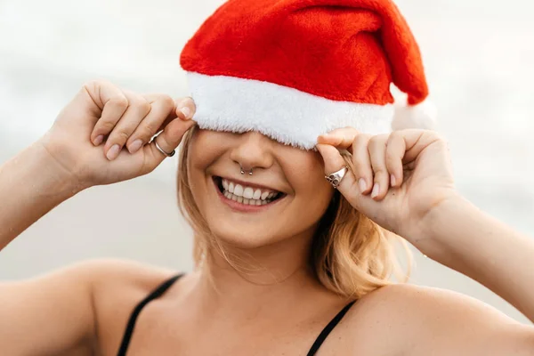 Привлекательная женщина в бикини в рождественской шляпе наслаждается зимними каникулами — стоковое фото